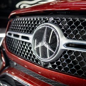 A close up of the front grille of a red mercedes benz car.