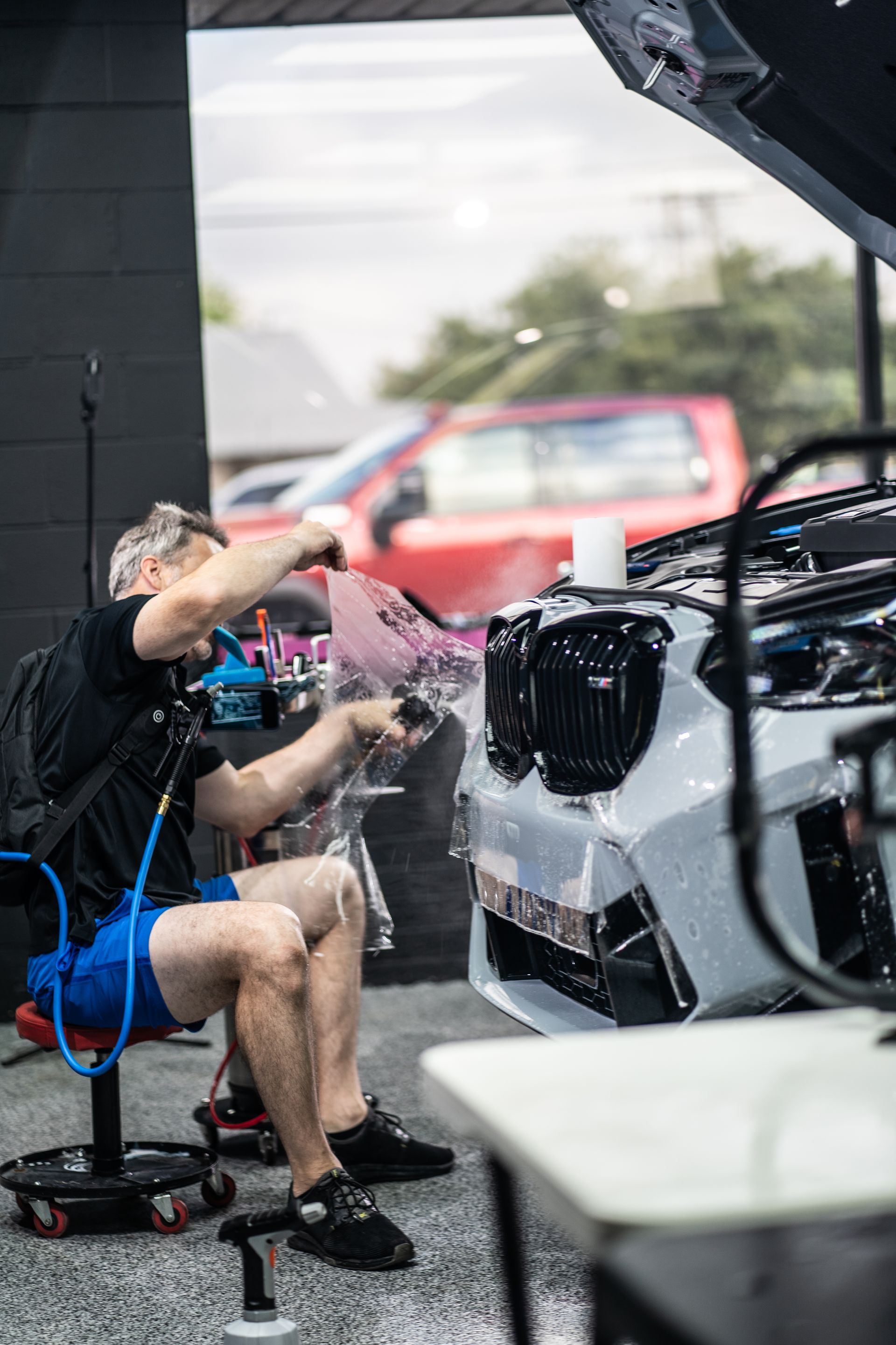 A man is sitting in a chair working on a car.