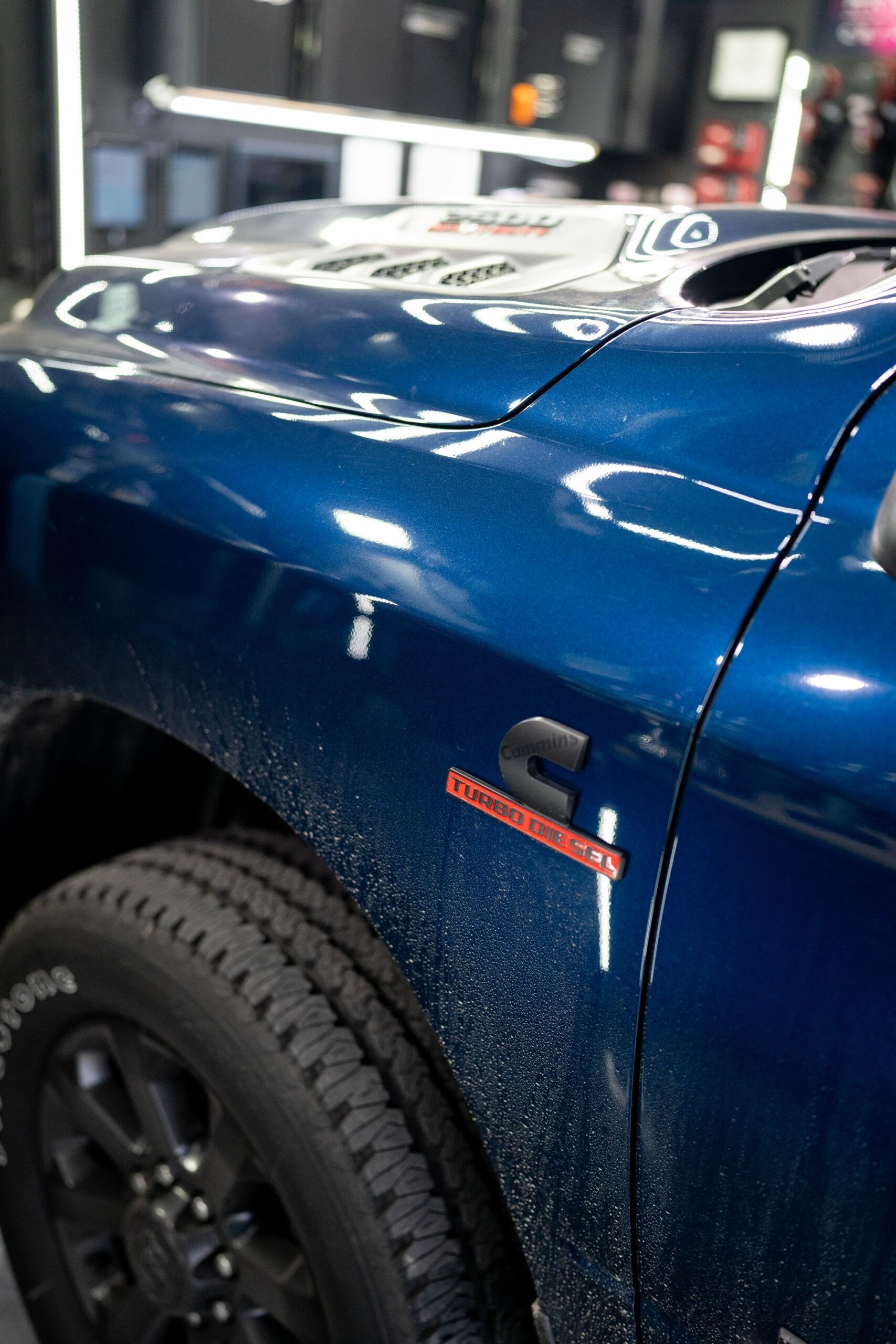 A close up of a blue truck parked in a garage.