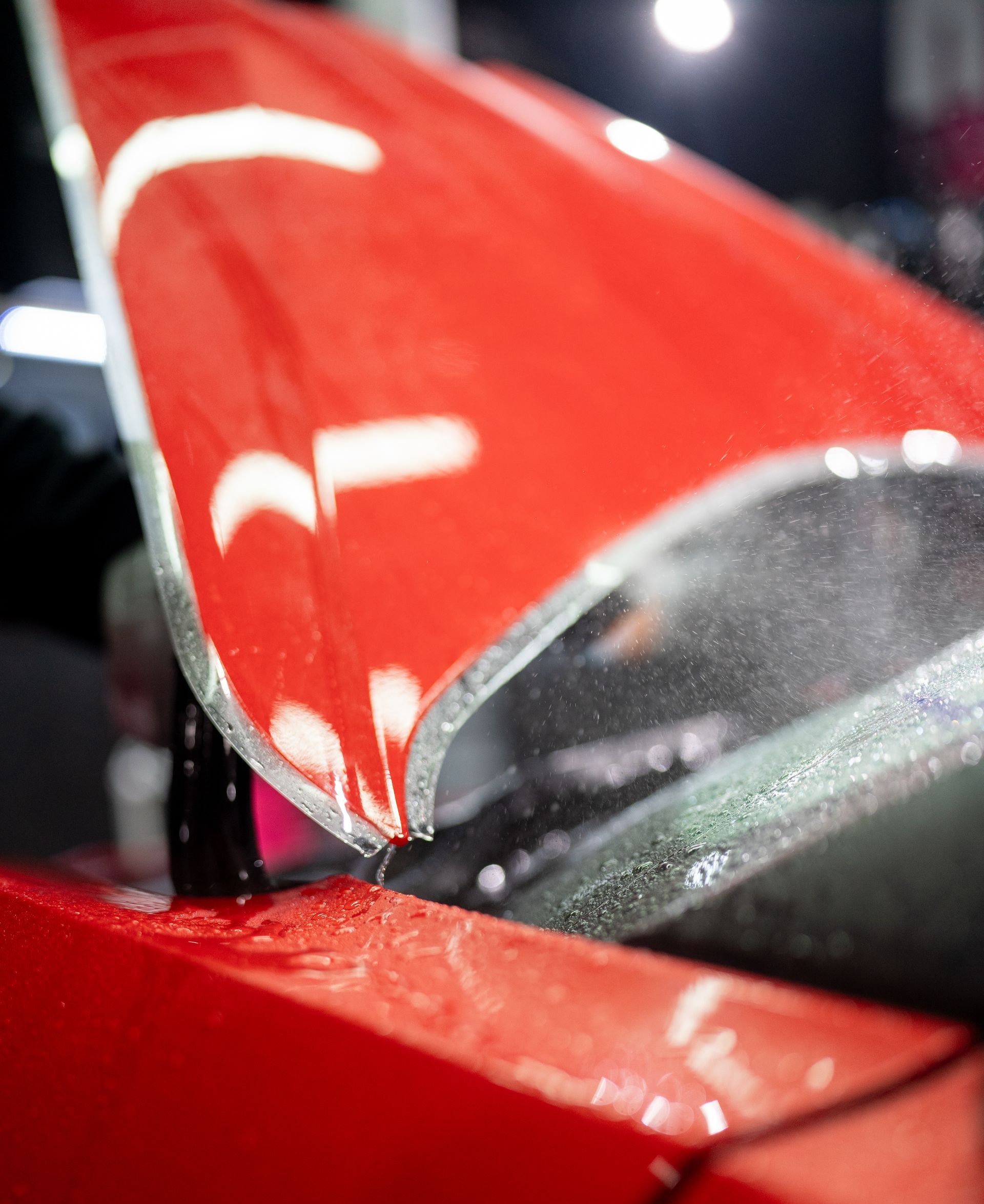 A red sports car is parked in a garage