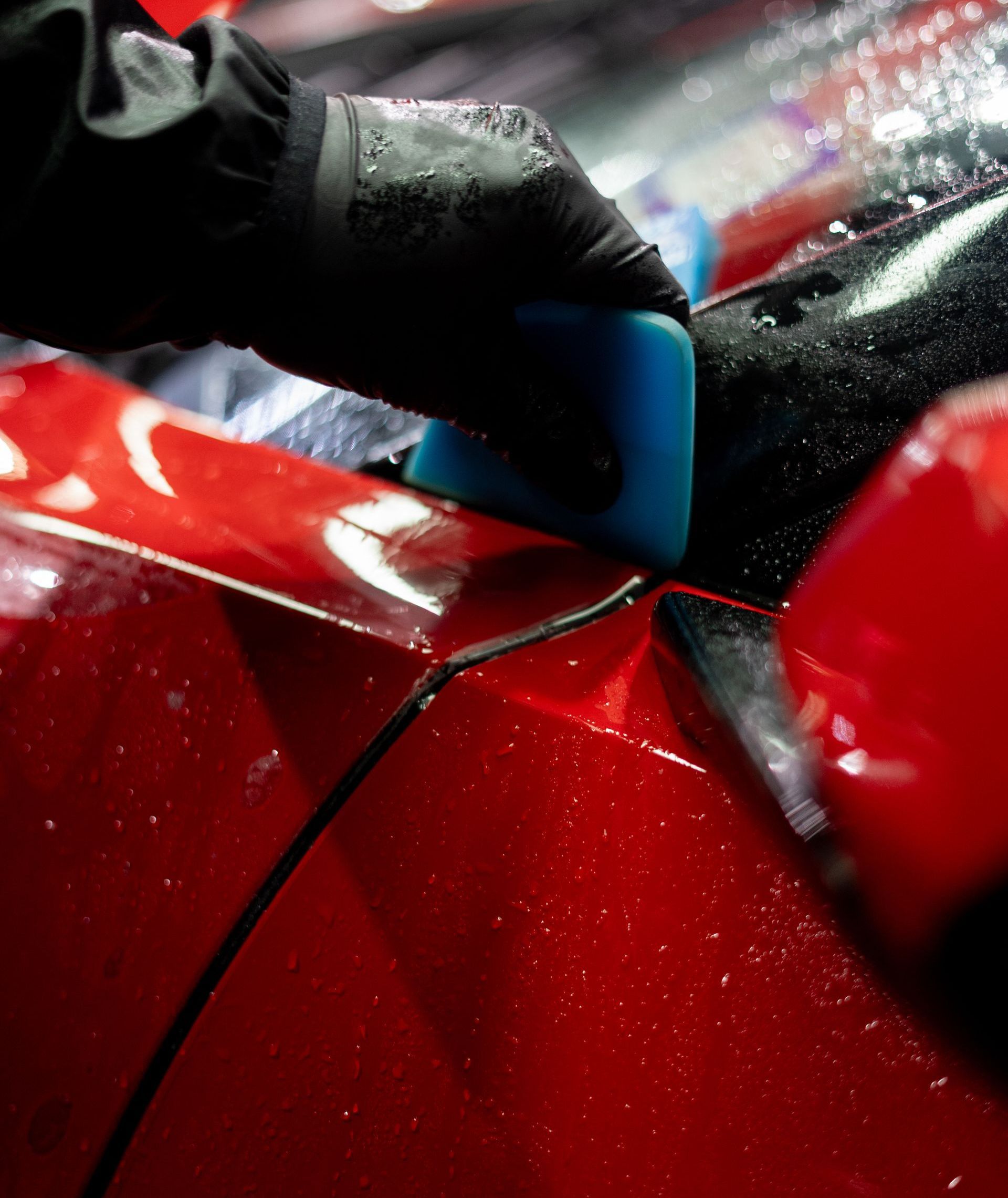 A man wearing a watch is cleaning a car