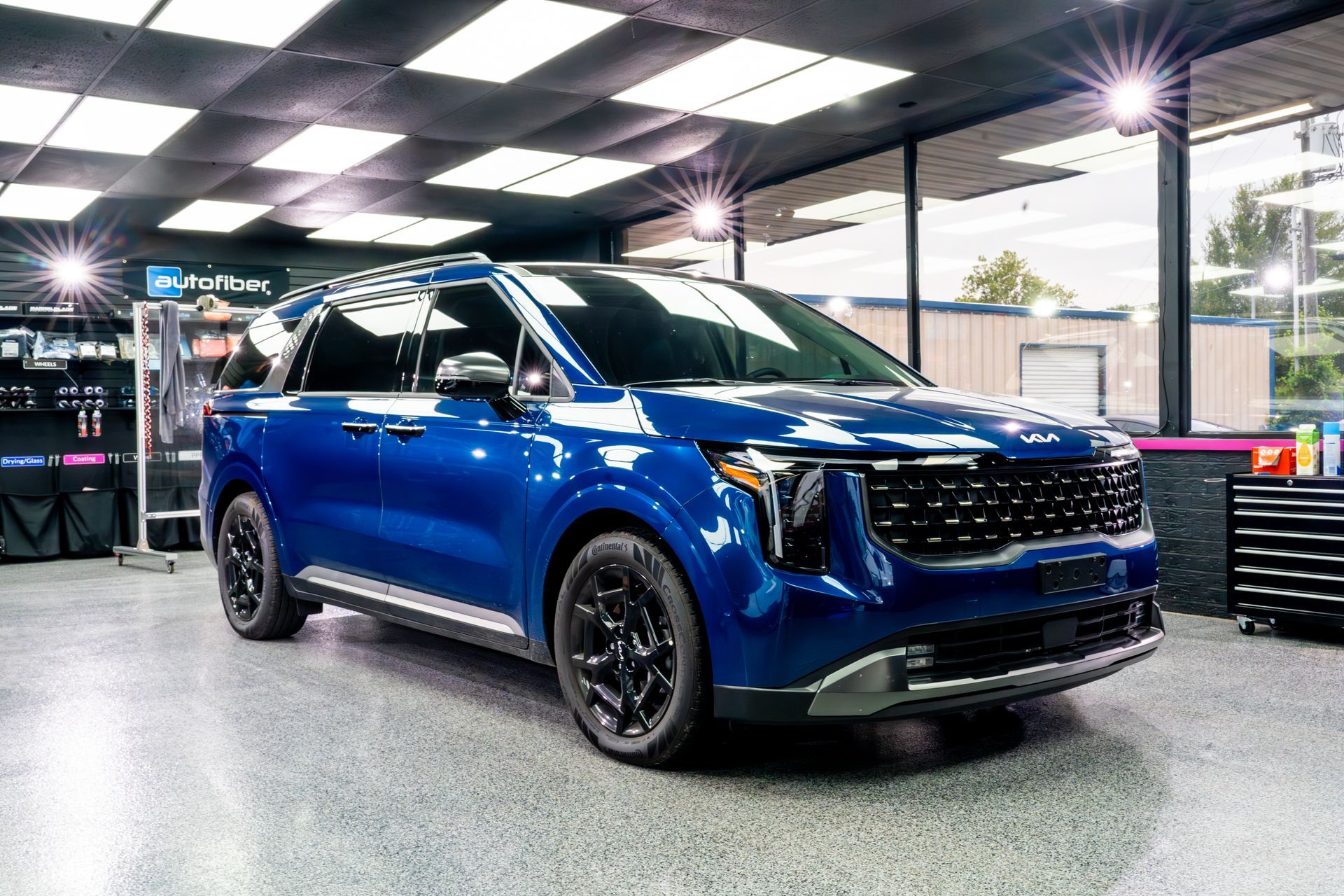 A blue car is parked in a garage.