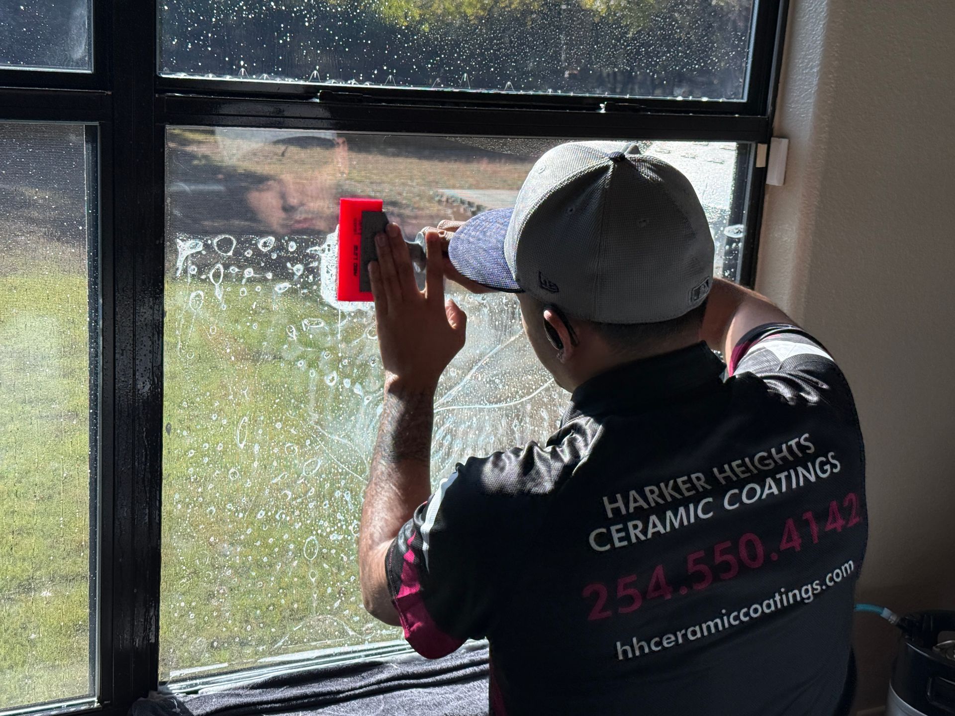 A person is installing a rear view mirror on a car.