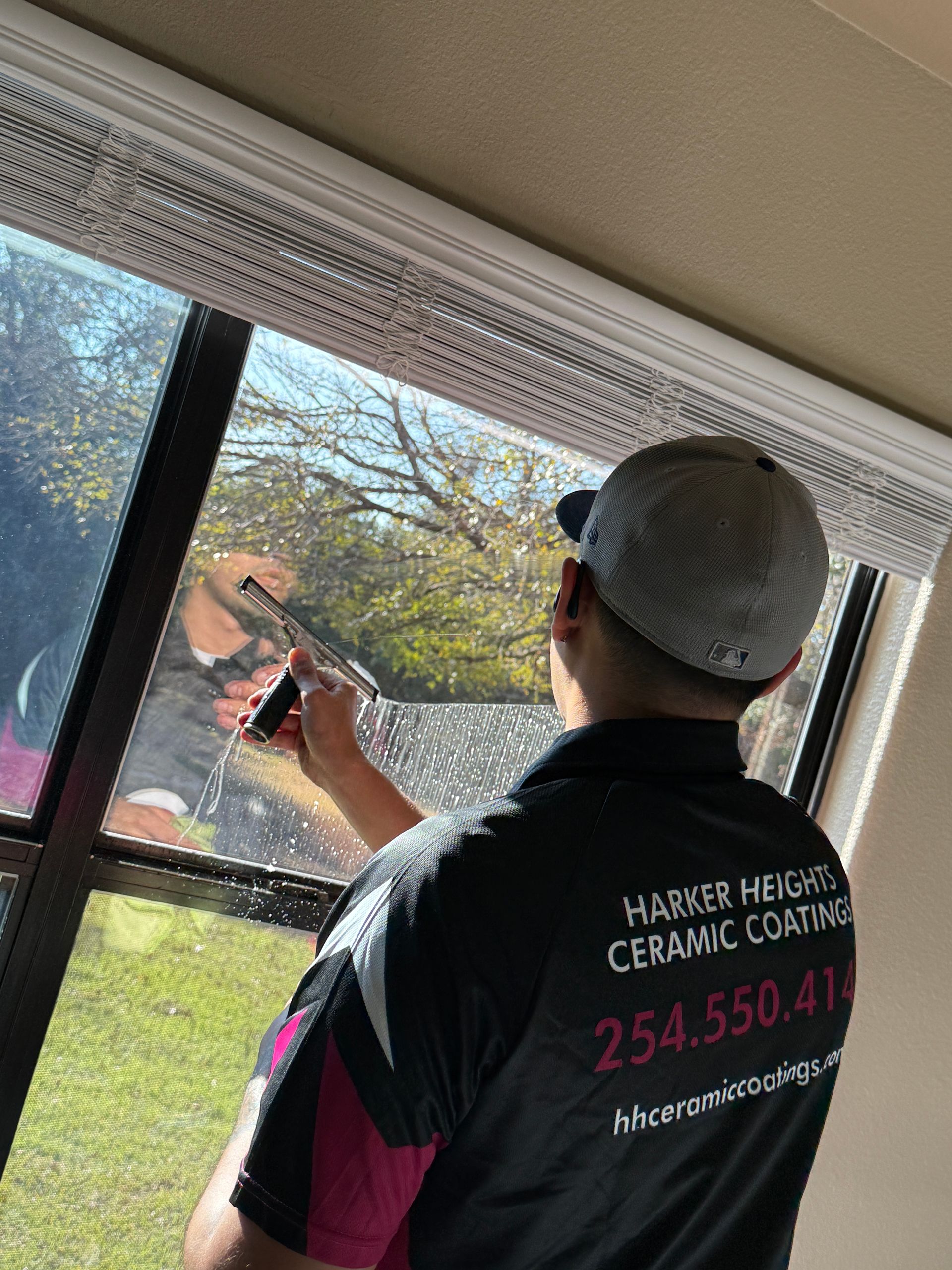 A person is applying tinted window film to a car window.