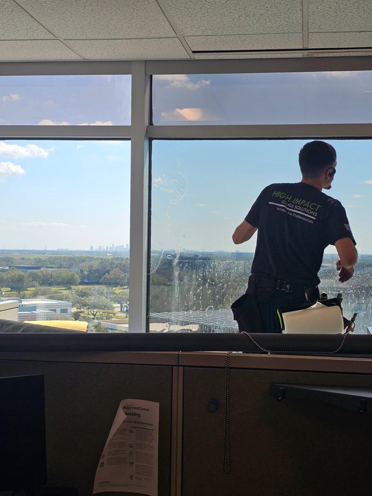 A person is cleaning a car window with a squeegee.