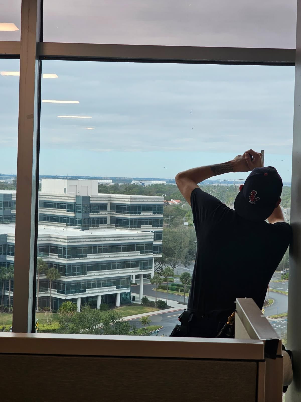 A person is applying tinted window film to a car window.