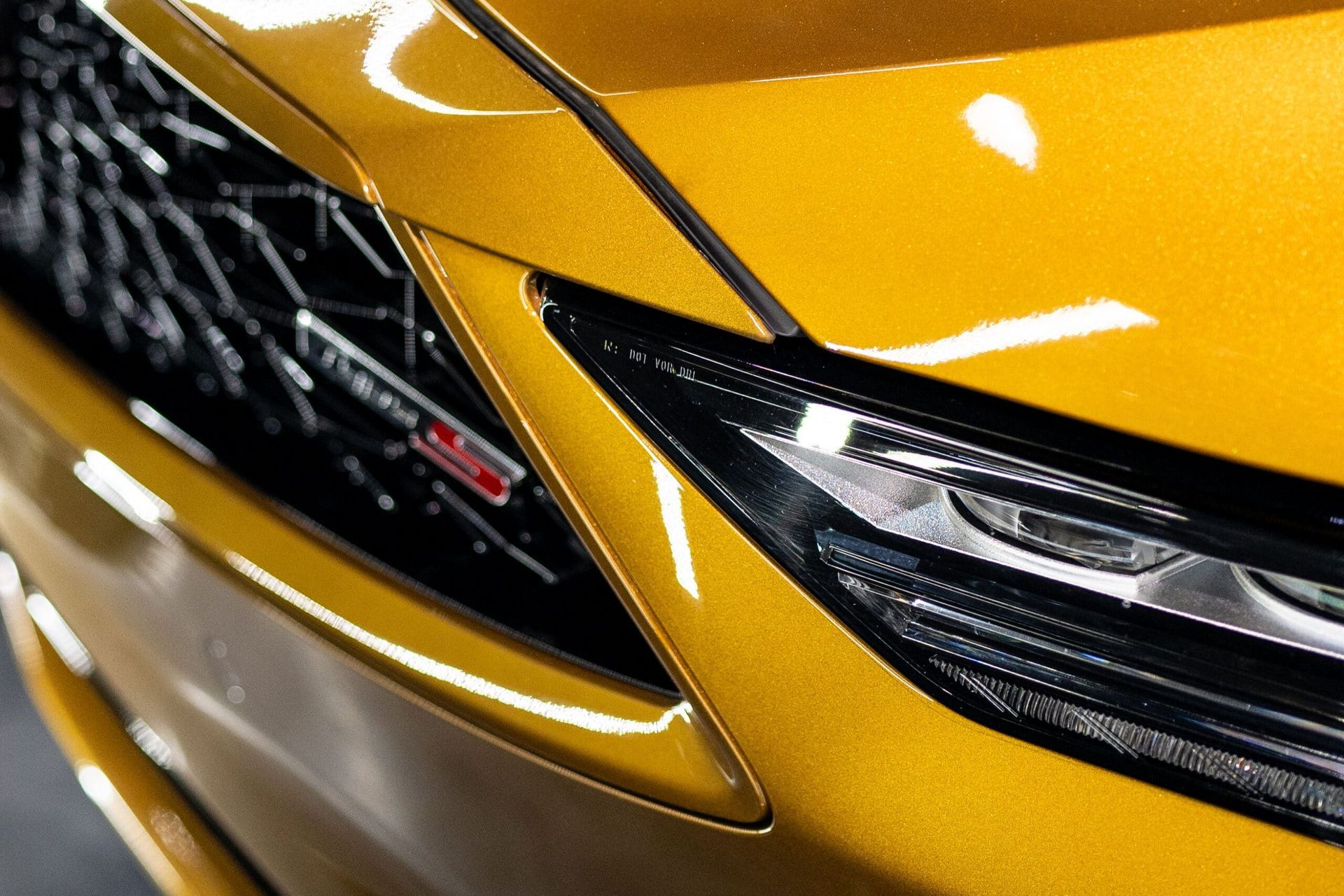 A close up of the front of a yellow car