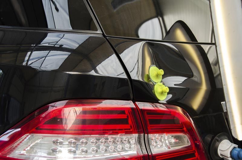 A close up of a car 's tail light being worked on