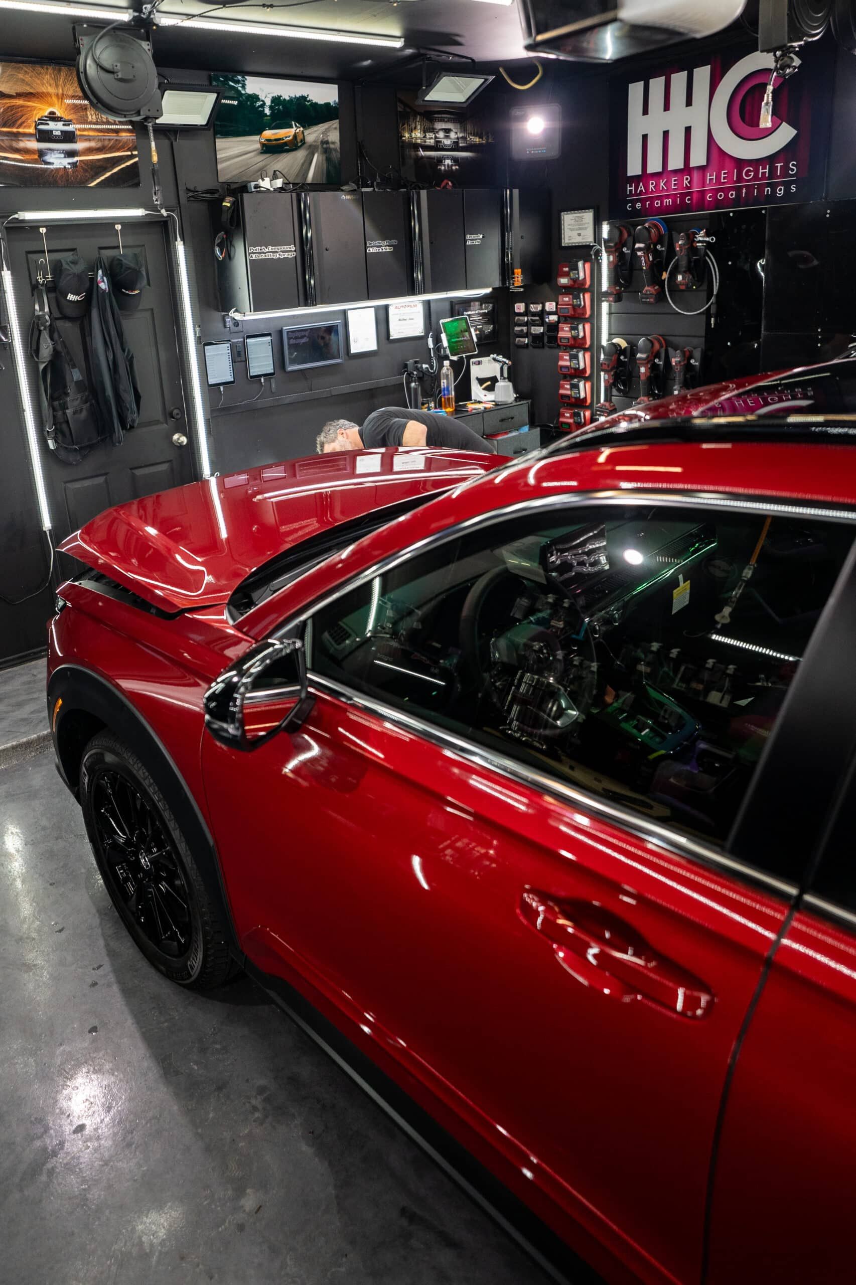 A red car is parked in a garage.
