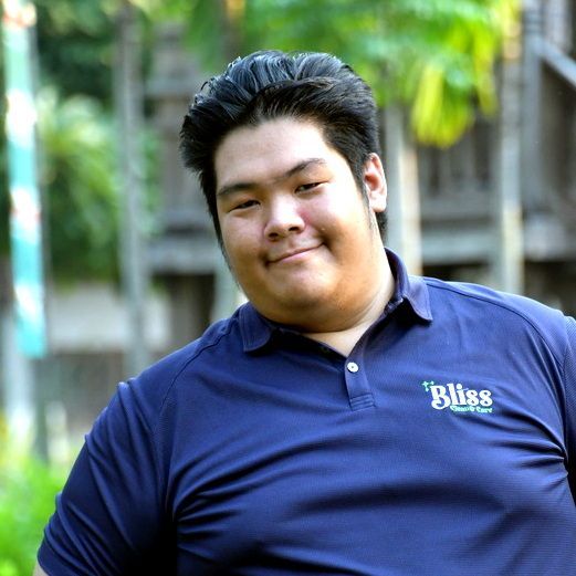 A woman in a green shirt is laughing with her mouth open