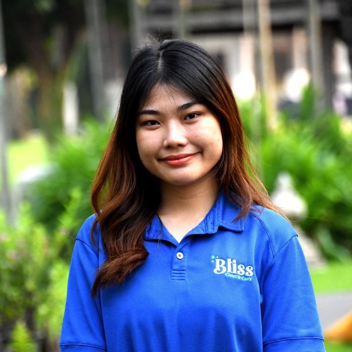 A woman in a green shirt is laughing with her mouth open