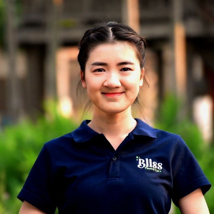 A woman in a green shirt is laughing with her mouth open