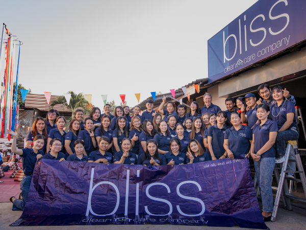 A group of people standing in front of a bliss sign