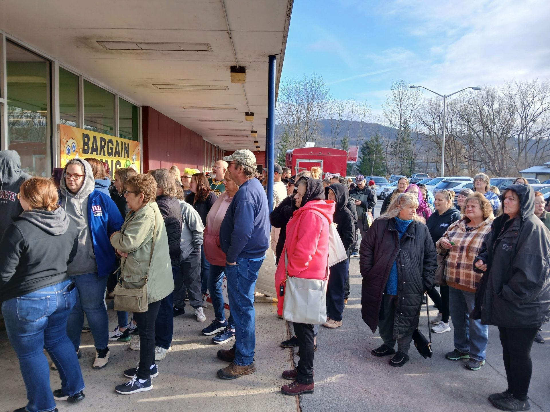 A warehouse filled with lots of cardboard boxes on wooden pallets.