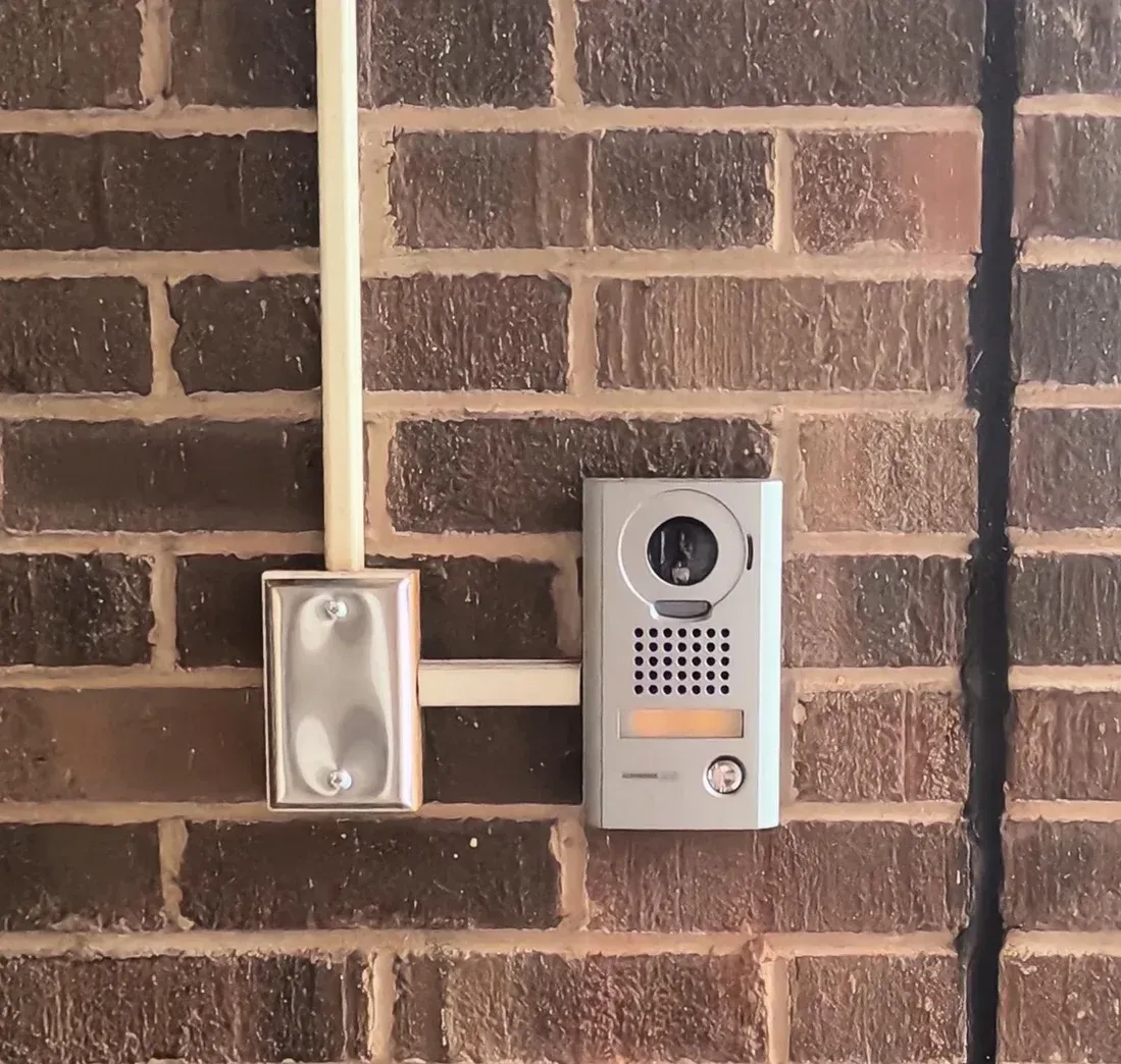 A person is using a fingerprint scanner to open a glass door.