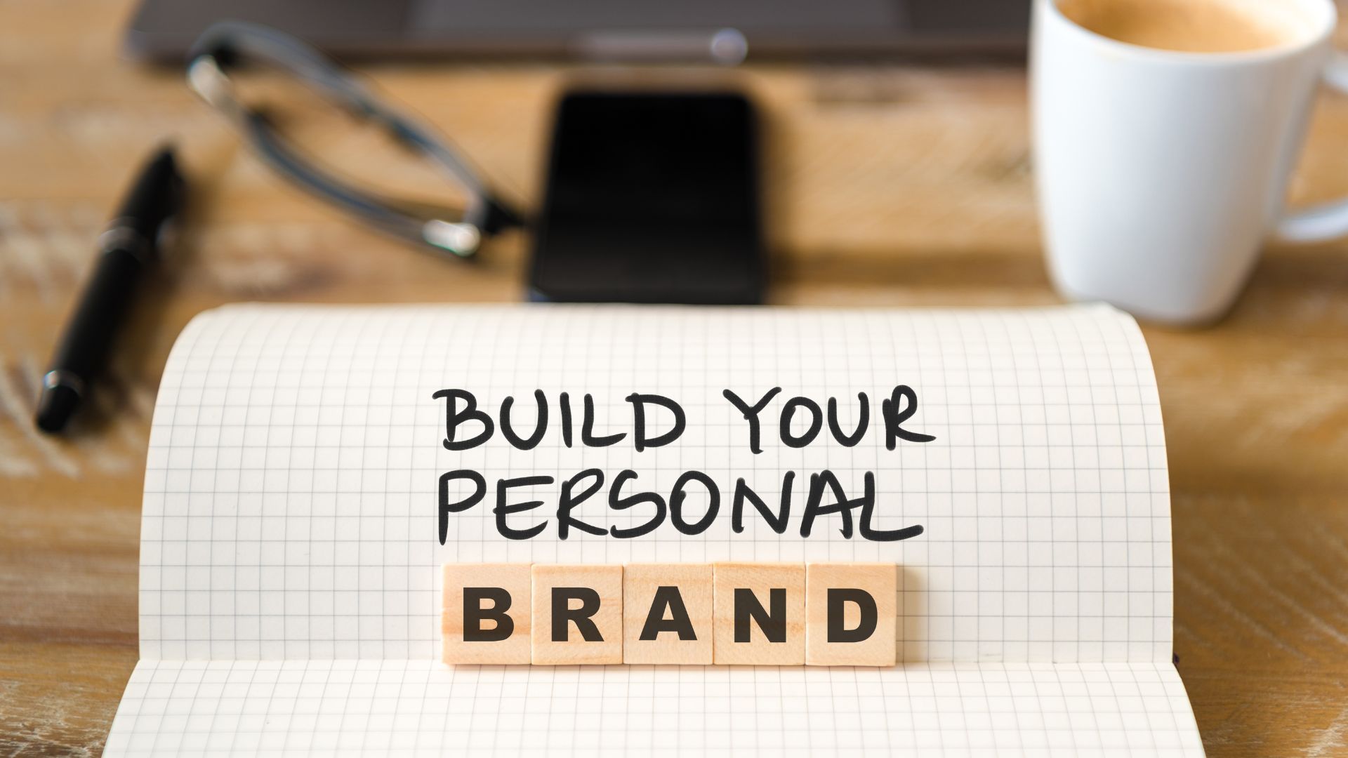 A notebook with the words `` build your personal brand '' written on it.