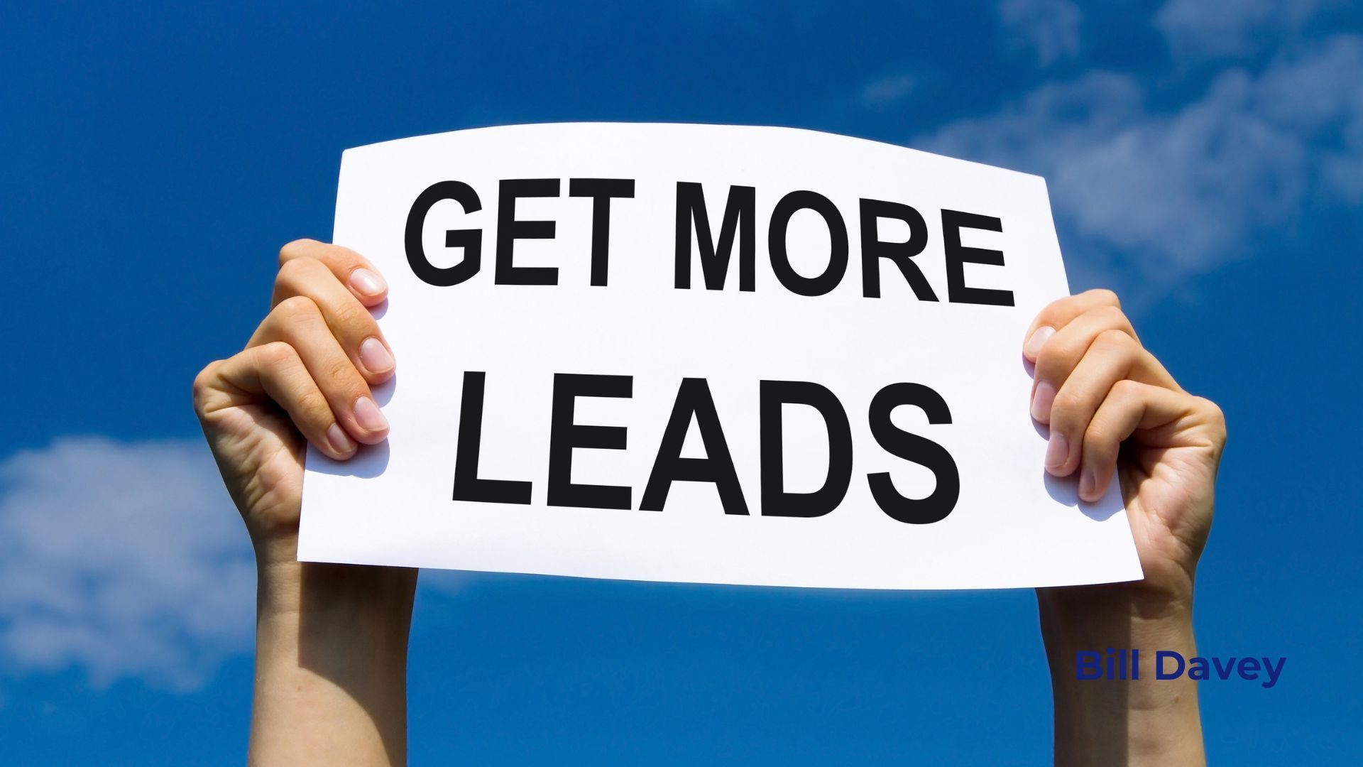 A person is holding a sign that says get more leads