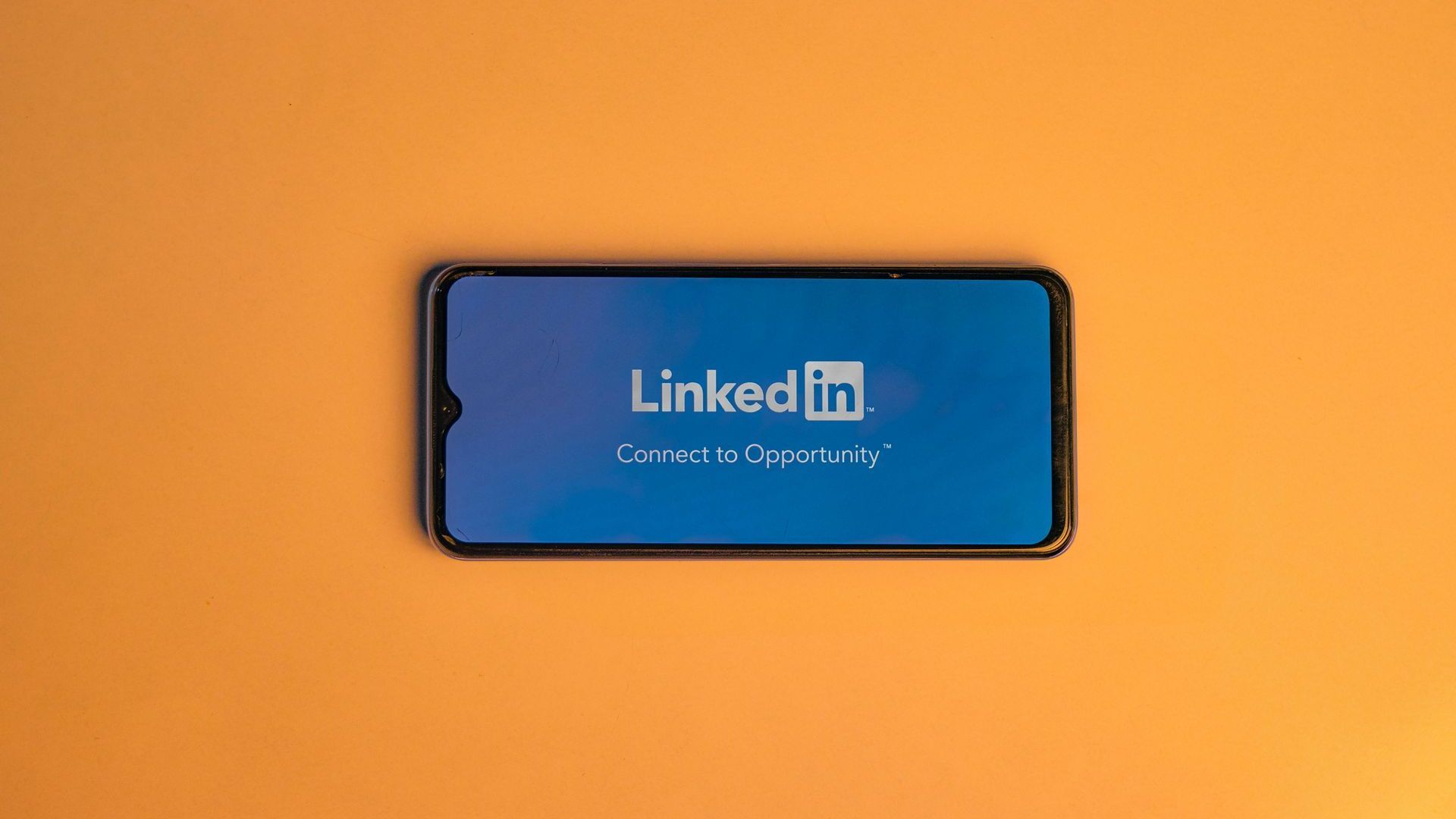 A cell phone with the linkedin logo on the screen.