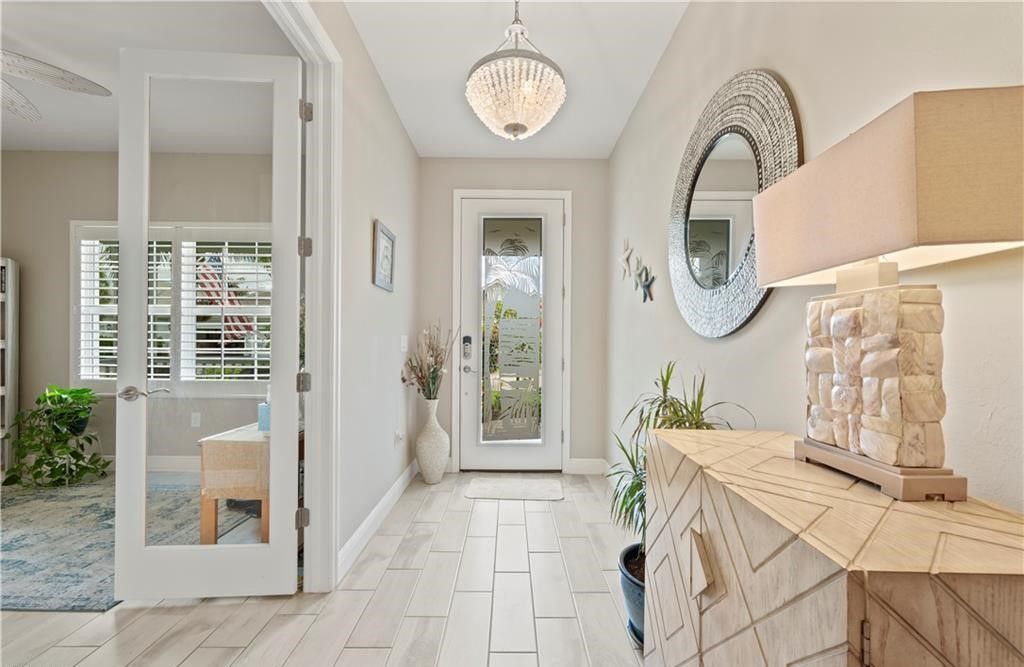 A hallway in a house with a table and a mirror.