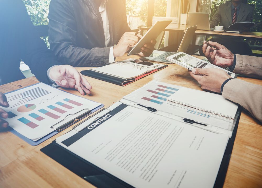 Business People at A Table Reviewing Charts — Bespoke Legal Group In Northern, NSW