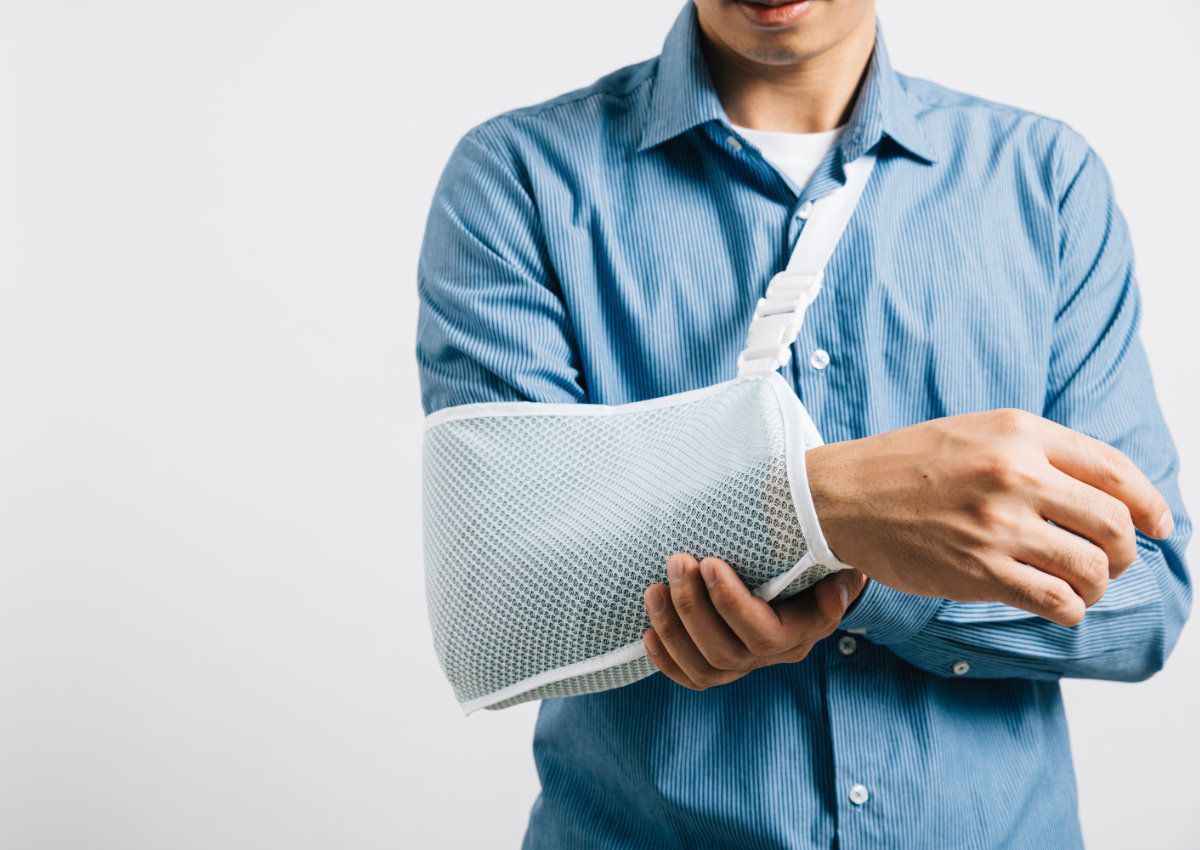 Man with arm in a sling, wearing a blue shirt — Bespoke Legal Group In Southport, QLD
