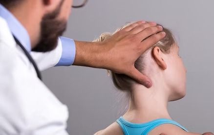 Doctor Examining a Young Girl's Neck, Hands on Her Head — Bespoke Personal Injury In Southport, QLD