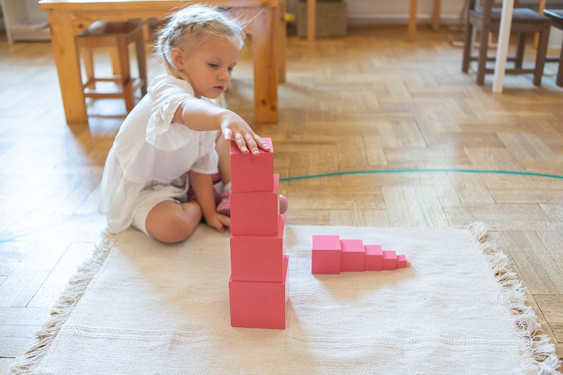 Montessori child playing with pink tower