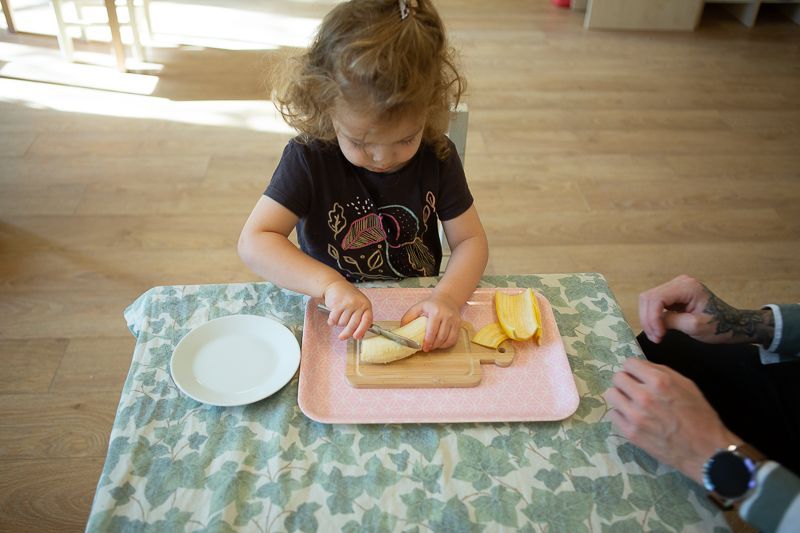 Montessori child cutting fruit