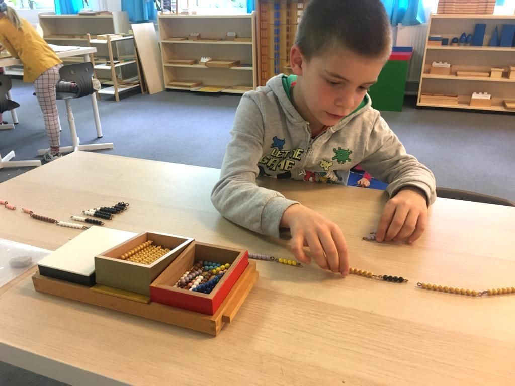 Elementry child playing with Montessori bead chains