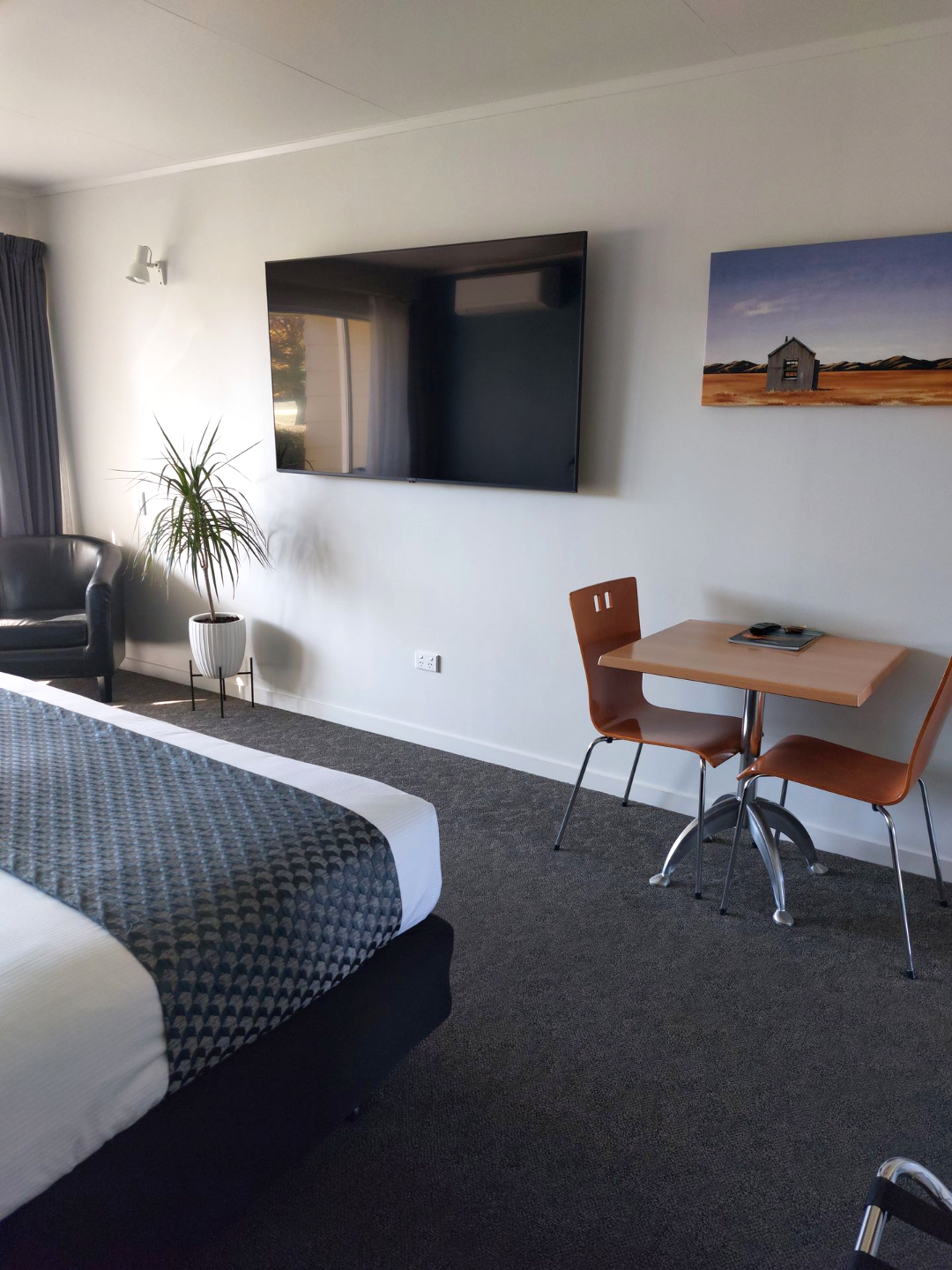 A quality motel room with a Super king bed, and doors opening up to a lawn and view over Cromwell Golf Course.