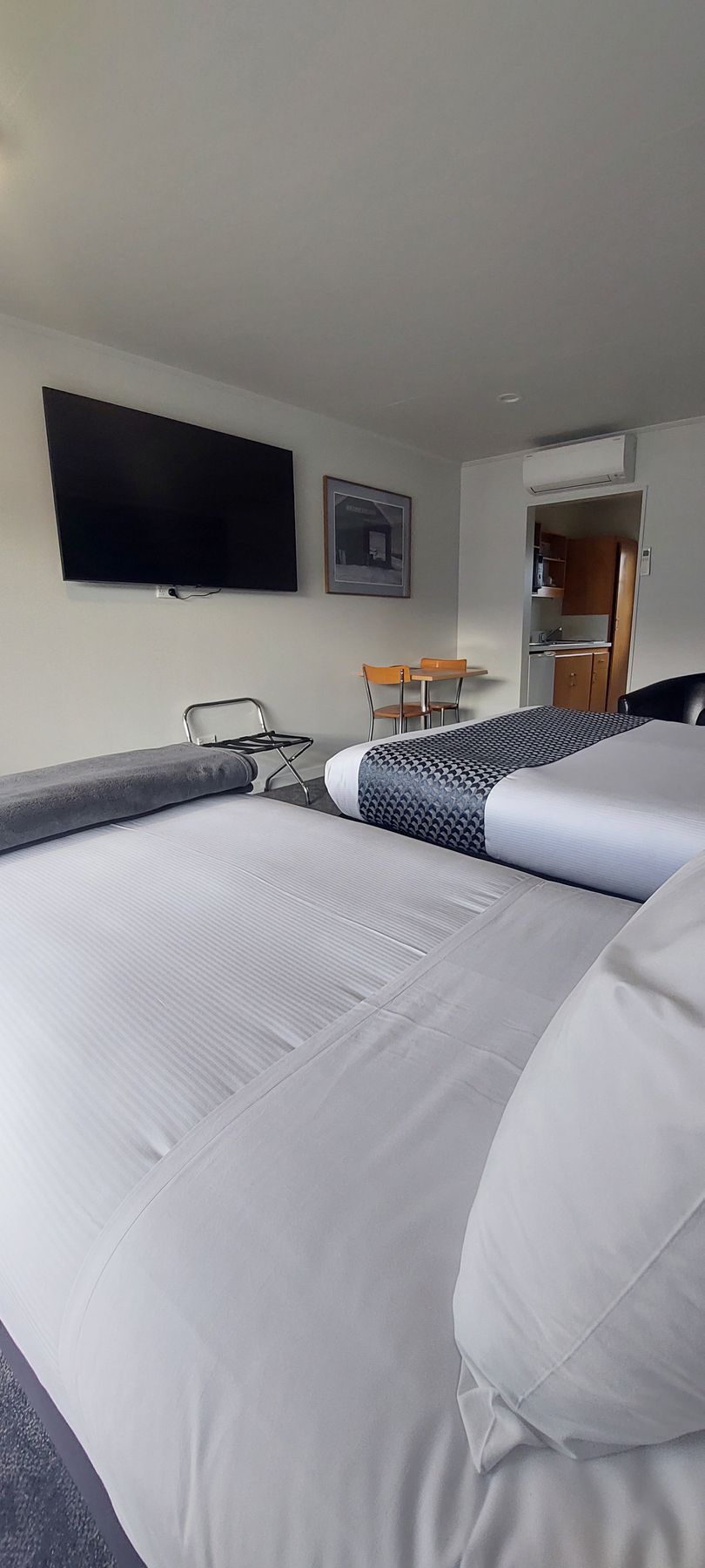A hotel room with two beds and a large window.