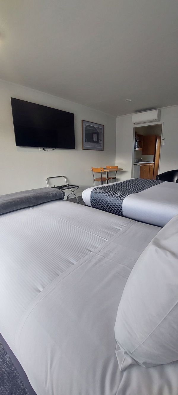 There is a patio with a table and chairs in front of a bedroom.
