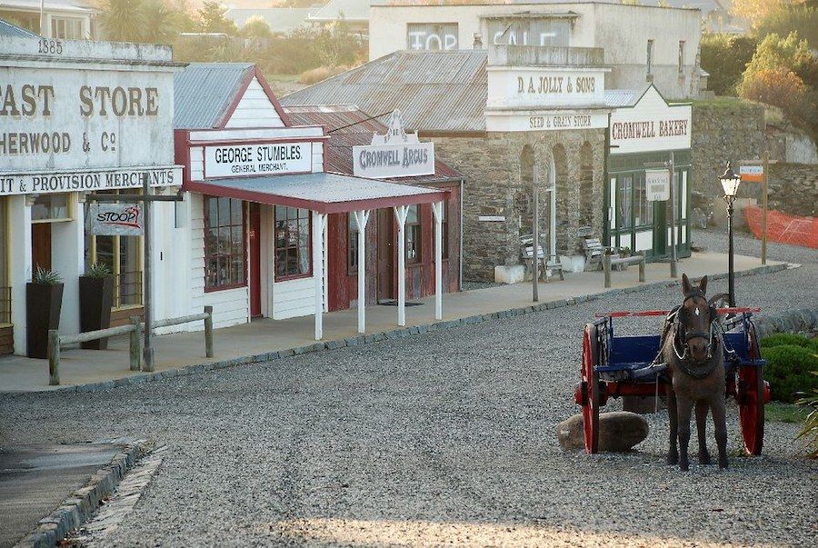 A horse drawn carriage is parked in front of historic cromwell