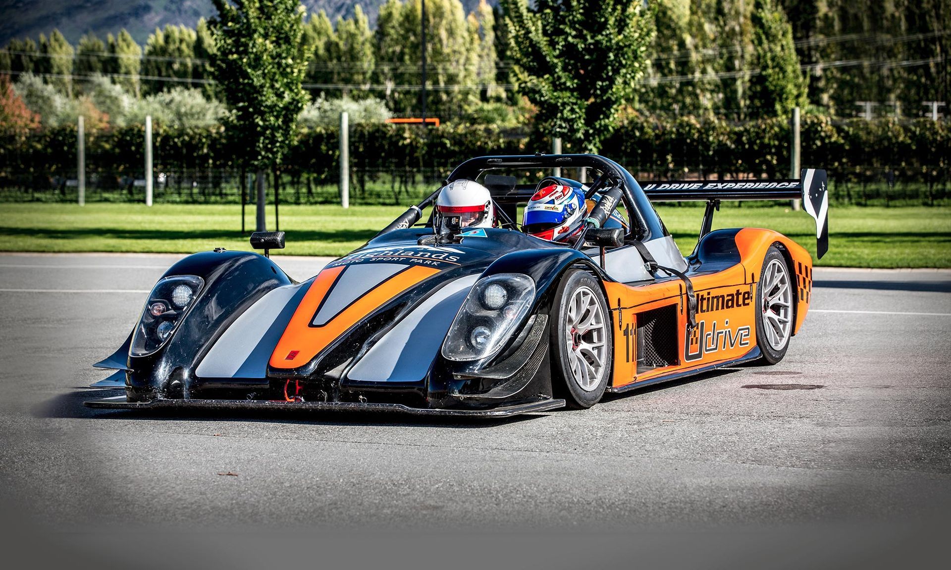 A man is driving a race car on a track.