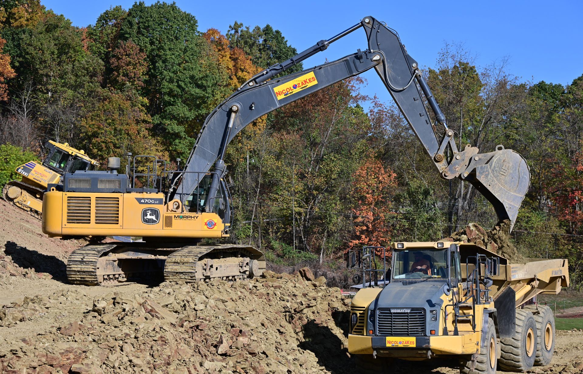A yellow excavator is digging a hole in the ground.