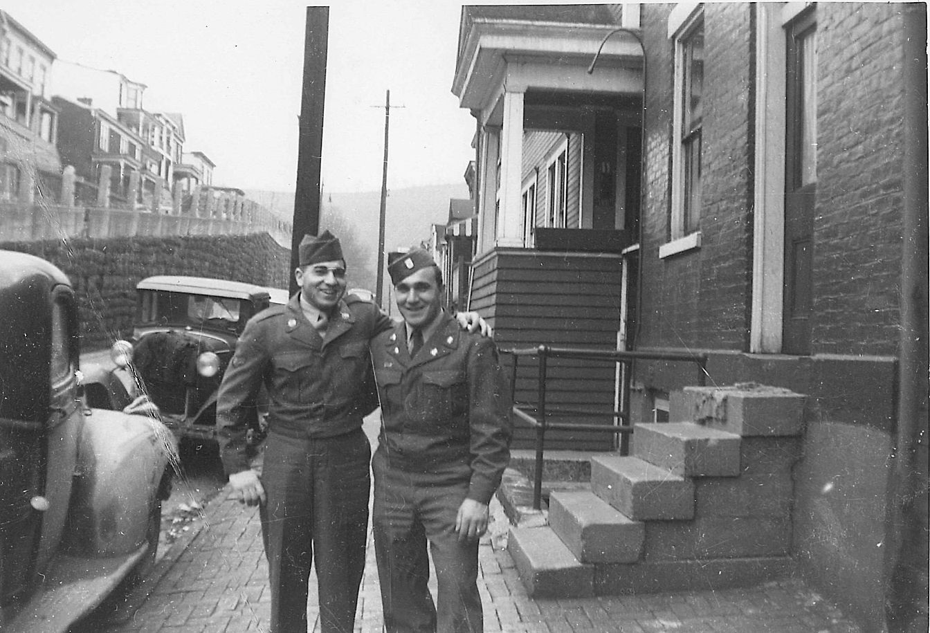 Two men in military uniforms are posing for a picture