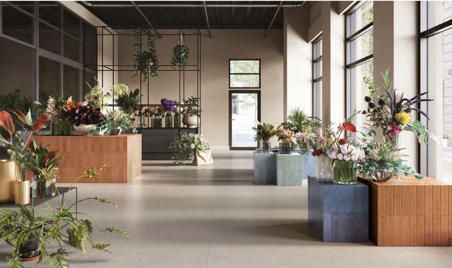 Interno di un negozio di fiori, esposizione di composizioni floreali colorate su piedistalli piastrellati, piante e grandi finestre.