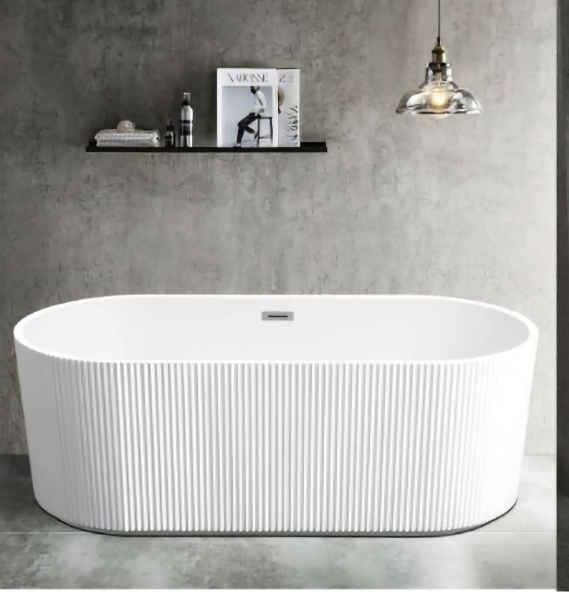 Vasca da bagno ovale bianca con motivo a coste verticali contro una parete grigia, mensola con decorazioni, lampada a sospensione.