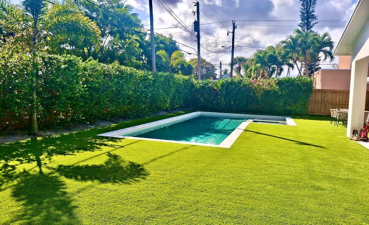 There is a large swimming pool in the backyard of a house.
