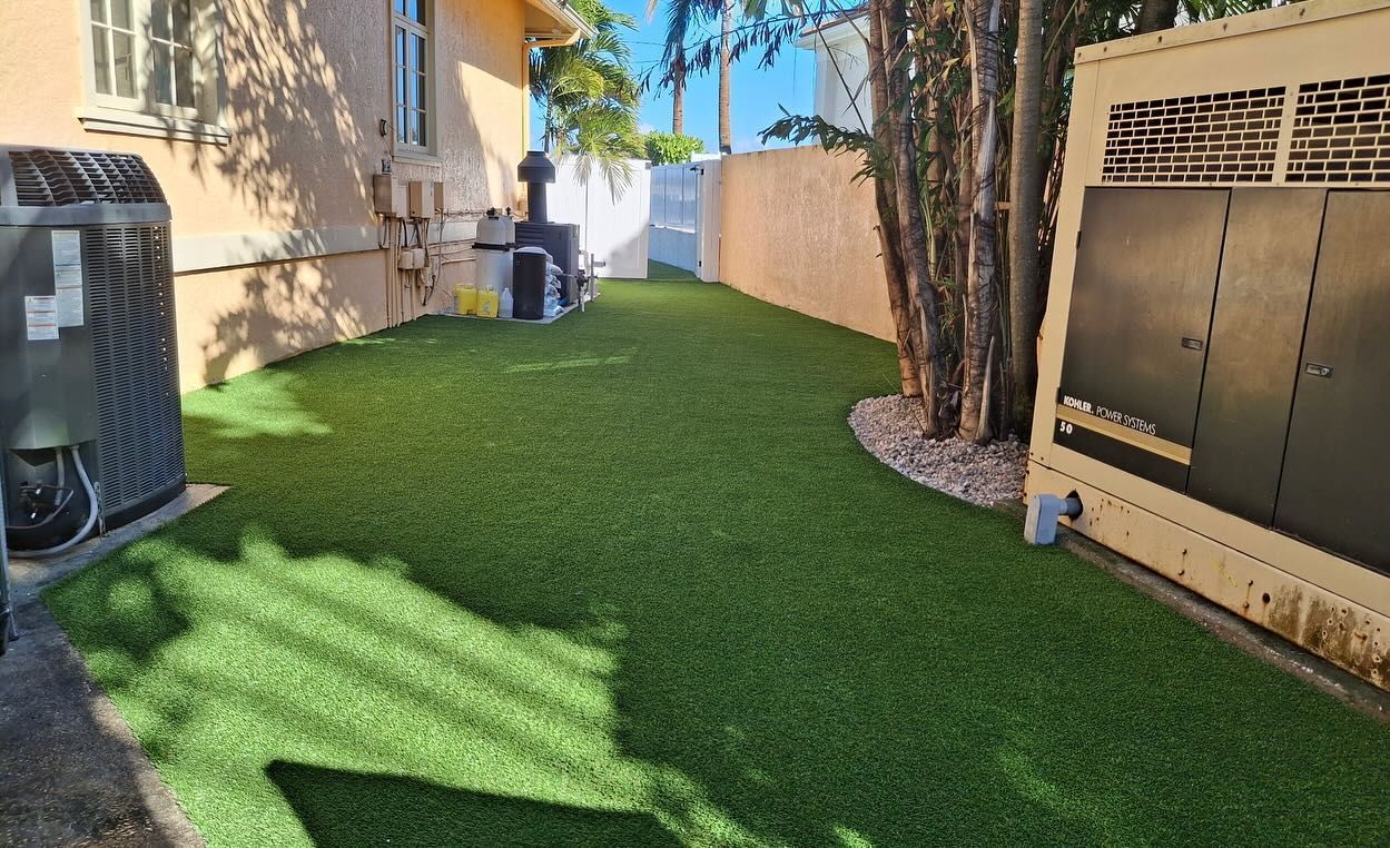 A backyard with a lot of green grass and a house in the background.
