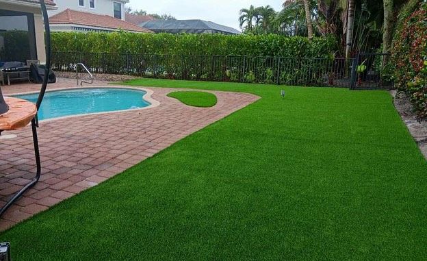 A backyard with a swimming pool and a lush green lawn.