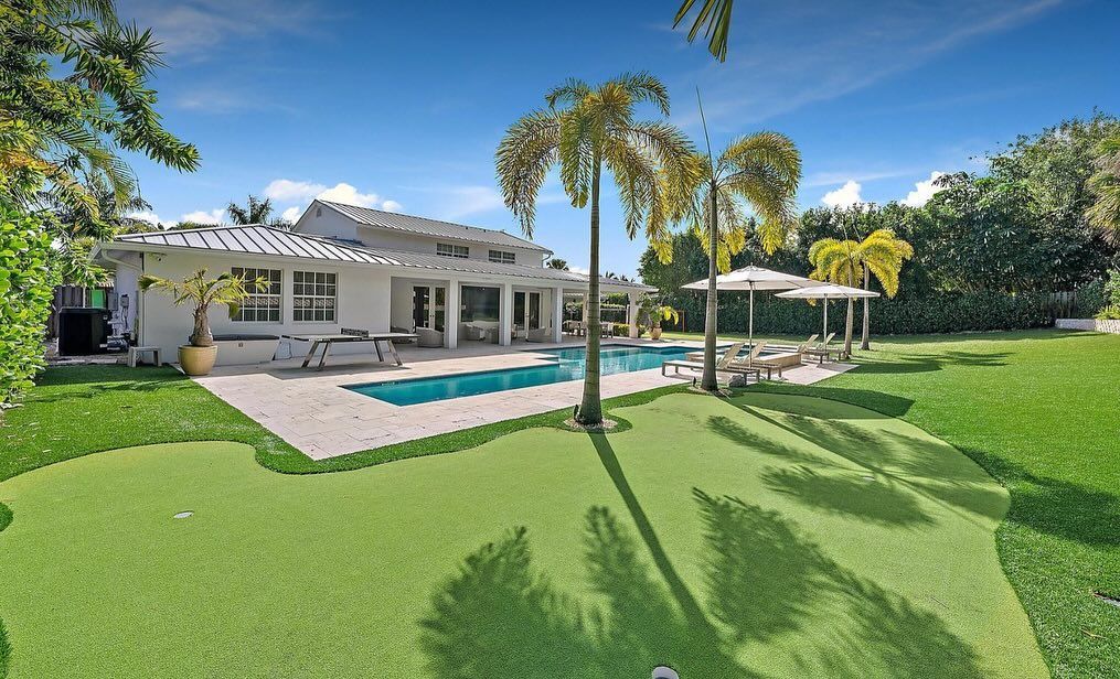 A large house with a swimming pool and a putting green