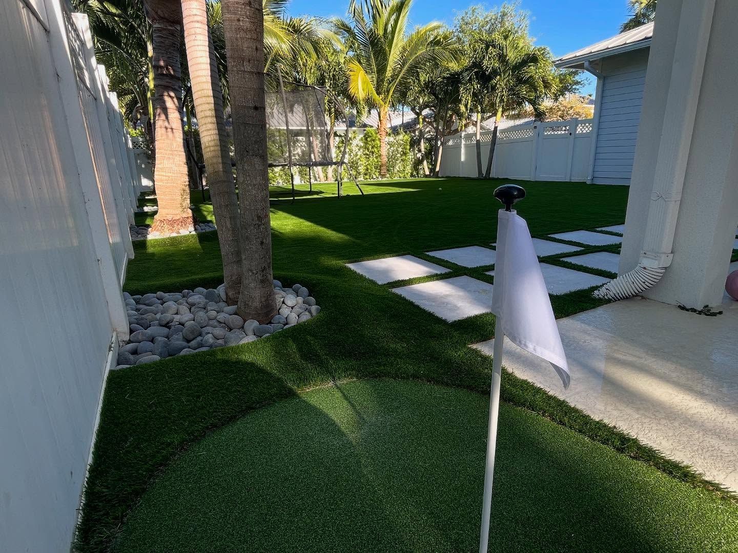 A white flag is sitting on top of a lush green lawn.