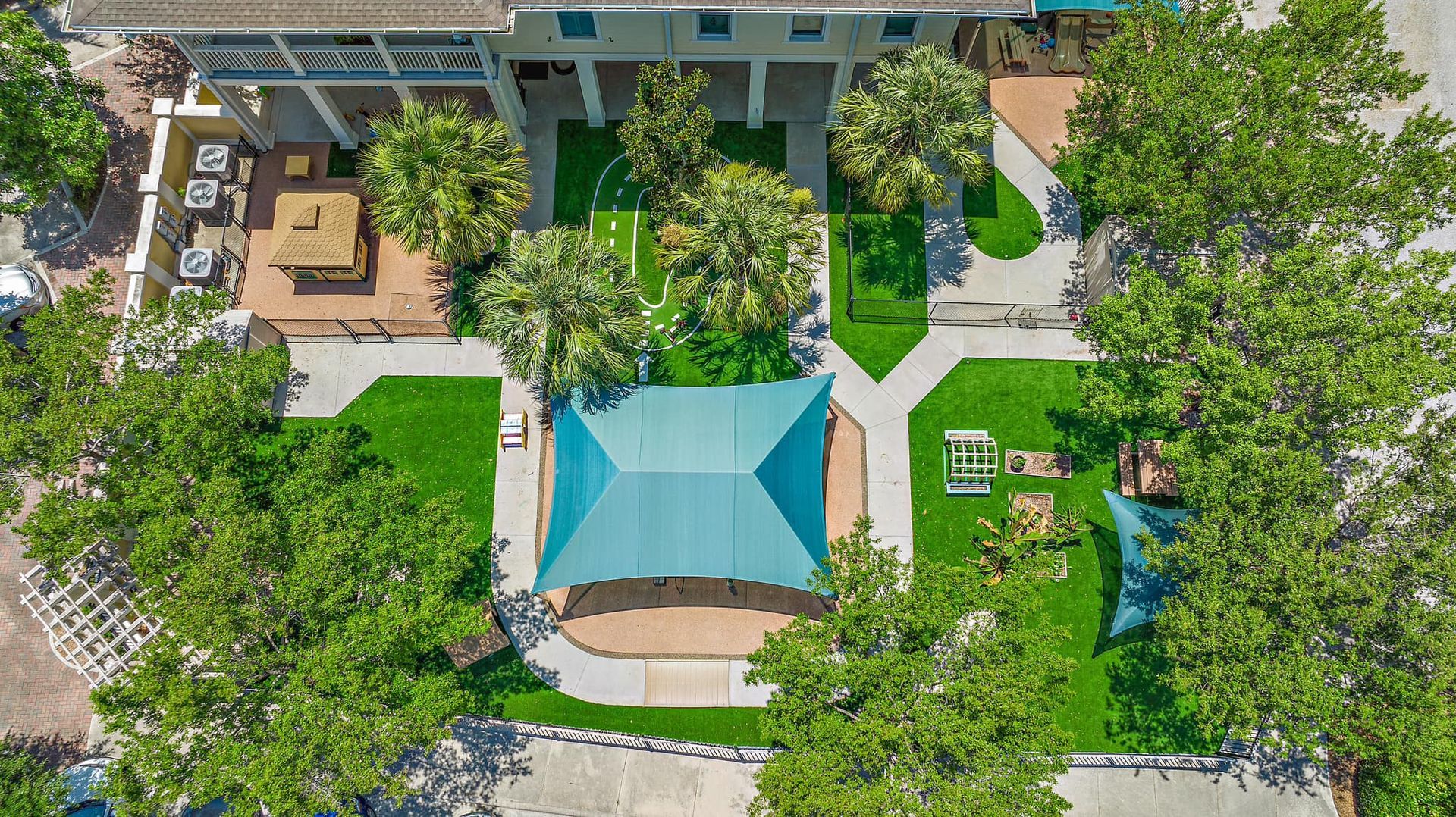 An aerial view of a park with a blue umbrella in the middle.
