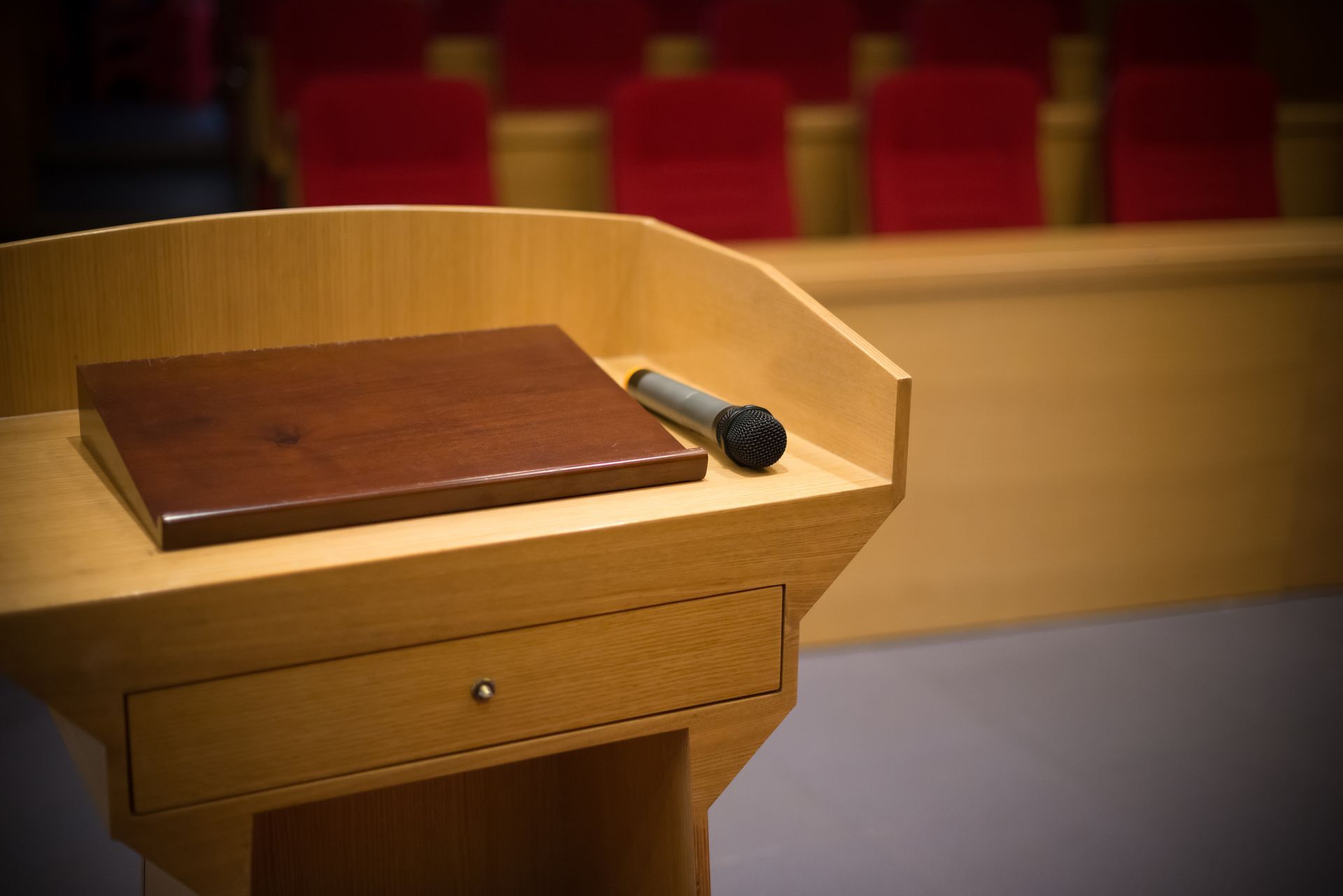 Un podio di legno con un microfono sopra in un auditorium.