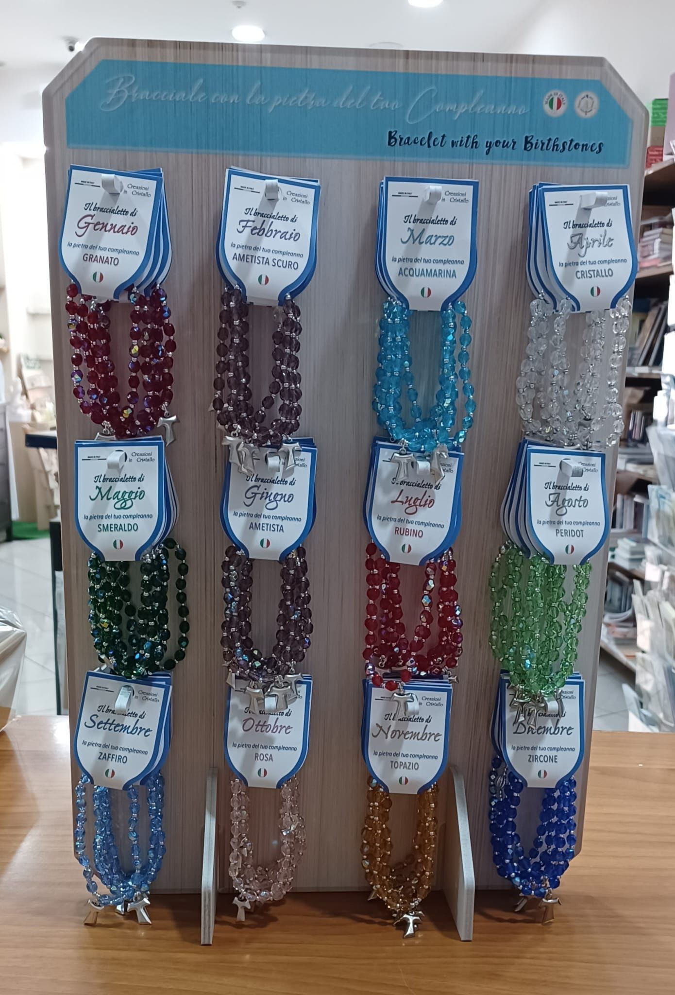 Un'esposizione di collane e braccialetti su un supporto di legno.