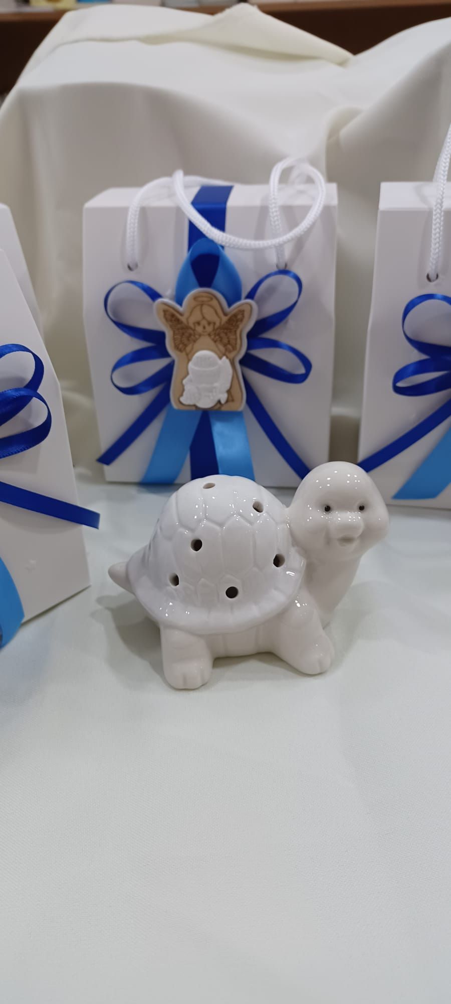 Una tartaruga bianca è seduta su un tavolo accanto a borse blu e bianche.