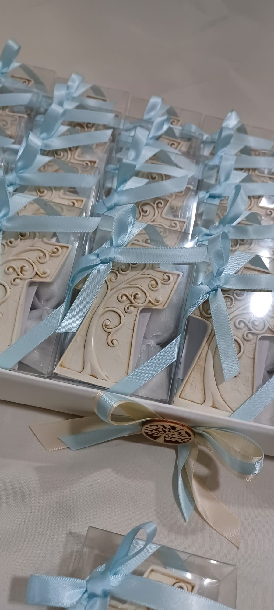 Una scatola di bomboniere per baby shower con nastri blu su un tavolo.