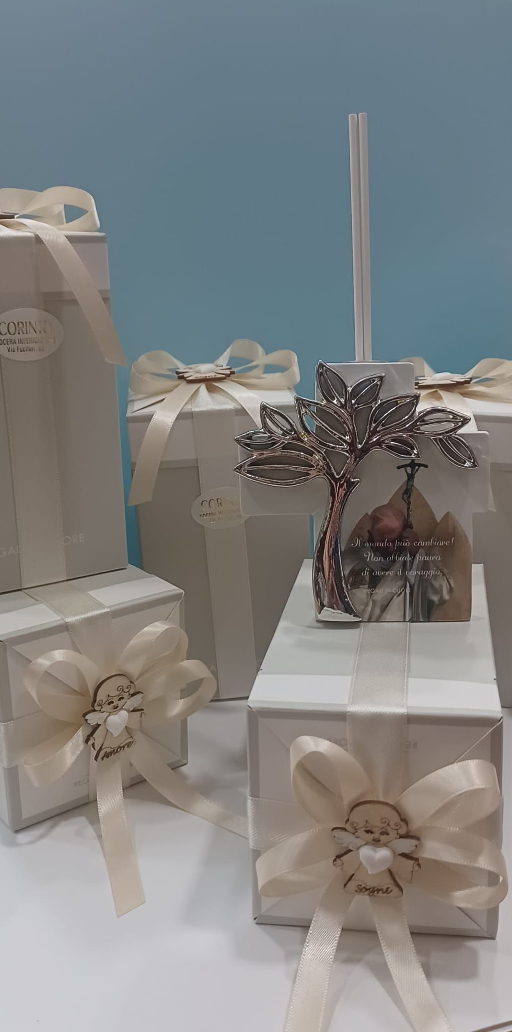 Un gruppo di scatole bianche con dei fiocchi sono appoggiate su un tavolo.