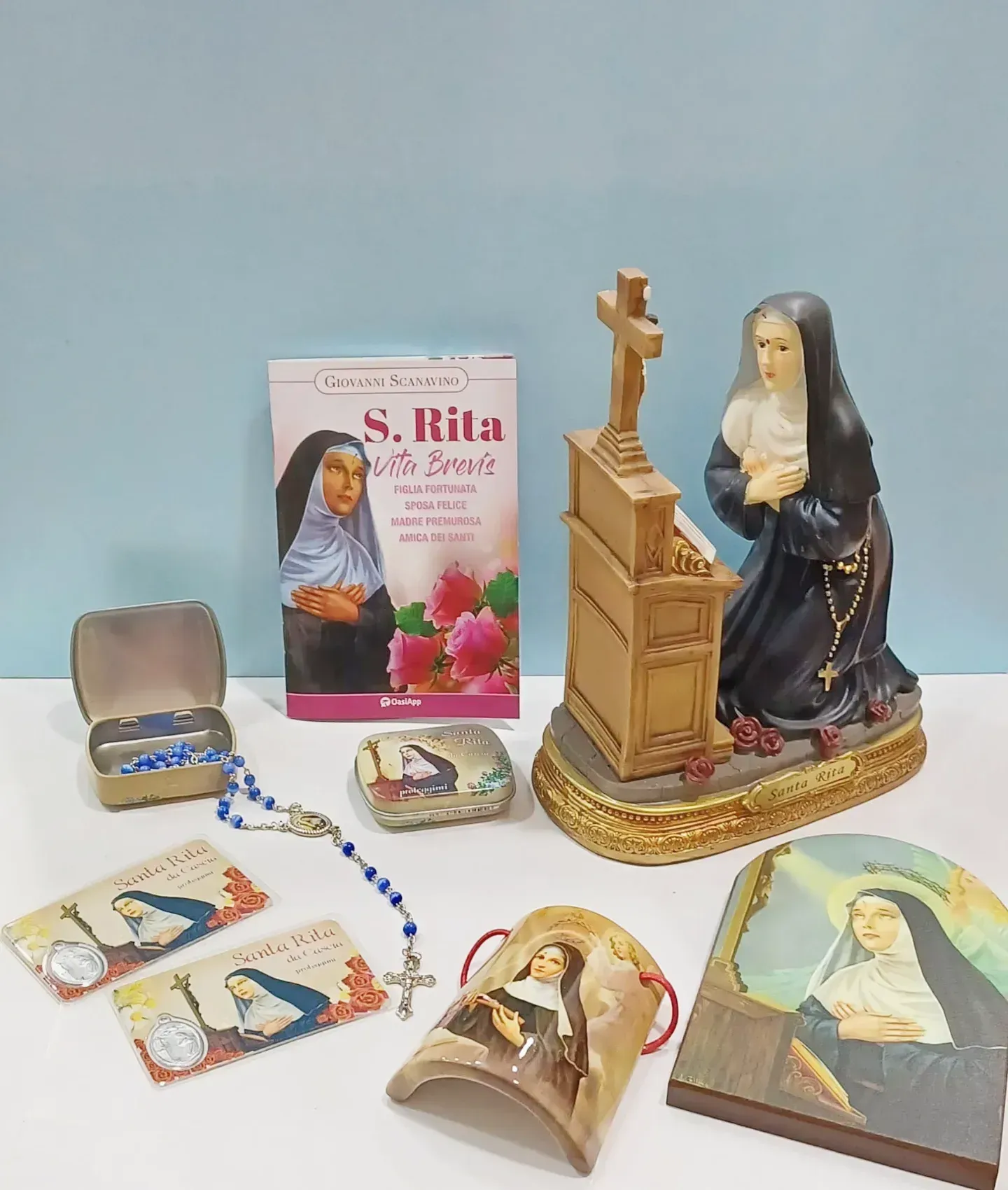 Una statua di una suora è seduta su un tavolo accanto a un libro